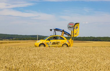 Vendeuvre-sur-bulunan, Fransa-6 Temmuz, 2017: Tour de France 2017 aşama 6 sırasında bir bölge tanıtım karavanda bisikletçiler önce buğday alanlarının BIC süslü araç geçer. BIC geniş bir lin sunan global bir şirket olduğunu