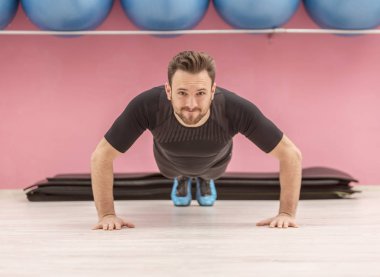 Şınav bir spor salonunda yakışıklı genç bir adam portresi.