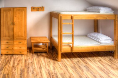Clean hostel room with wooden bunk beds. clipart
