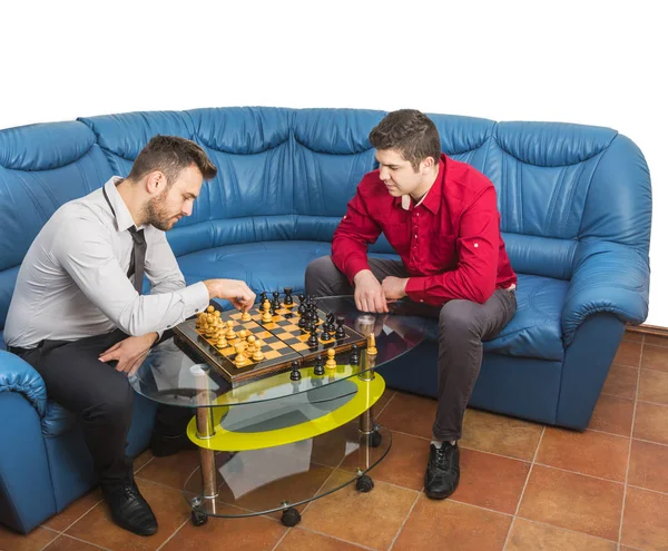 Два Друга Играют Шахматы Синем Диване — стоковое фото