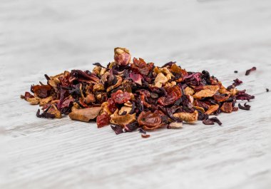 Beyaz ahşap bir yüzeyüzerinde bir demet meyve çayı.