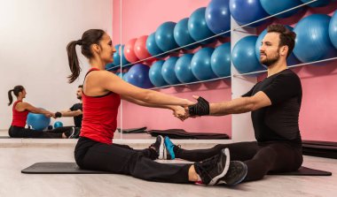 Spor salonunda egzersiz yapan genç bir çift.