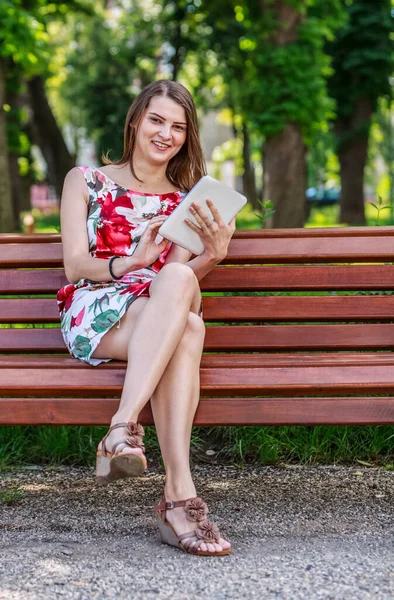 Imagem Uma Jovem Mulher Usando Tablet Sentado Banco Parque — Fotografia de Stock