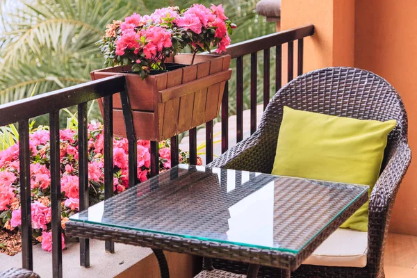 Раттен стол и кресло с подушками на балконе — стоковое фото