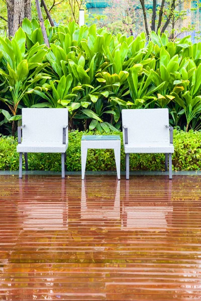 Rotanstoelen en tafel in lege tuin — Stockfoto