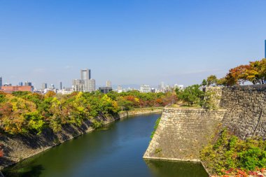Sonbaharda güzel şehir manzarası, renkli orman ve hendek ve eski tarz şehir duvarı, Osaka Kalesi Parkı, Osaka, Japonya