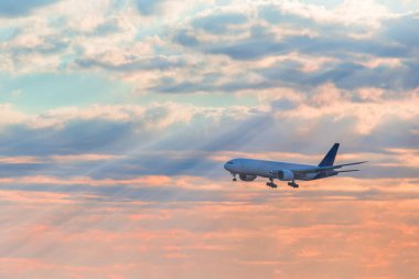 İniş yapan uçak sabah güneş ışığı ve bulutlarla gökyüzünde uçuyor. Seyahat geçmişi. Yolcu uçağı. Ticari uçak. Özel jet.