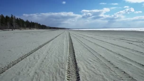 Перспектива следов шин на песчаном пляже — стоковое видео