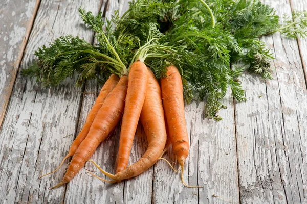 close-up view of fresh carrots over white rustic wood background