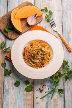 İstiridye ve çatal ile ahşap masa üzerinde kabak ile makarna