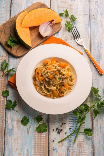 İstiridye ve çatal ile ahşap masa üzerinde kabak ile makarna