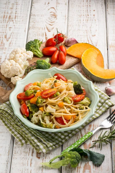 Spaghetti with broccoli cabbage pumpkin and tomatoes — Stock Photo, Image