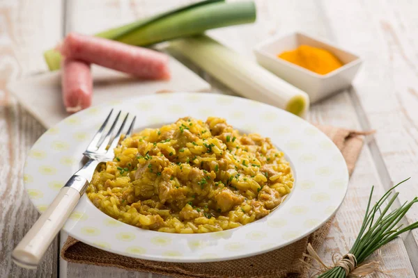 Risotto with sausage leek turmeric and chive — Stock Photo, Image