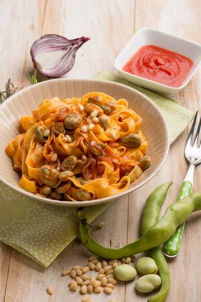 Fettuccine pasta with broad bean tomato and pine nuts — Stock Photo, Image