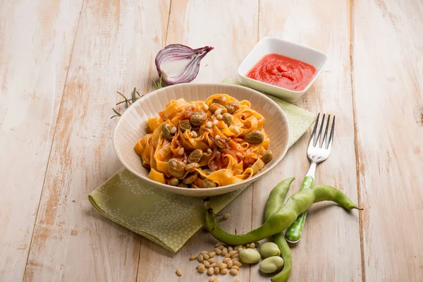 Macarrão fettuccine com tomate de feijão largo e pinhões — Fotografia de Stock