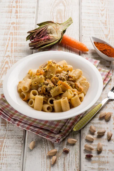 Pasta with artichokes cream carrots and pistachio nuts — Stock Photo, Image