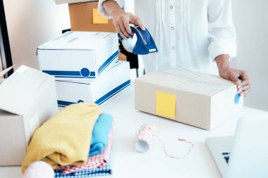 İş Kuruluşu KOBİ kavramı. Genç girişimci, küçük işletme sahibi, evde çalışıyor, ambalaj ve teslimat durumu.