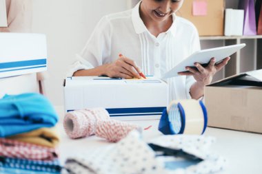 E-posta veya Web sitesi üzerinden müşteri siparişlerini denetleme ve paketleri için ürün Ofis donanımı hazırlamak için bilgisayar kullanarak çevrimiçi satıcı sahibi genç işe başlamak. 