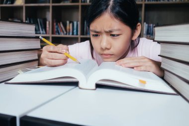 Eğitim kavramı. Okul Kütüphanesi kız okuma ve yazma ve ödev. Seft çalışma ve öğrenme