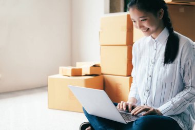 E-posta veya Web sitesi üzerinden müşteri siparişlerini denetleme ve paketleri için ürün Ofis donanımı hazırlamak için bilgisayar kullanarak çevrimiçi satıcı sahibi genç işe başlamak