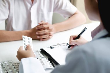 Hapları ile şişe tutan ve reçete yazma doktor el. Sağlık, tıp ve eczacılık kavramı.