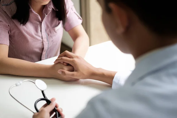 Doctor comforting patient at consulting room