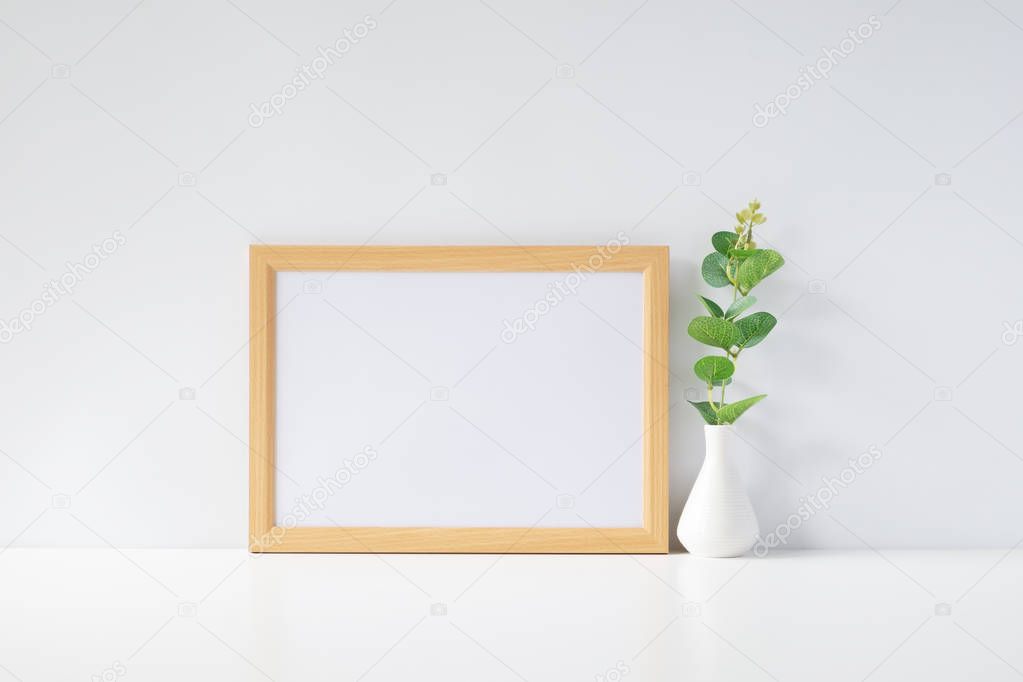 Mock up horizontal photo frame with green plant on table, home decoration.
