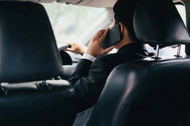 Arabada telefon ile genç iş adamı. Mobil ofis.