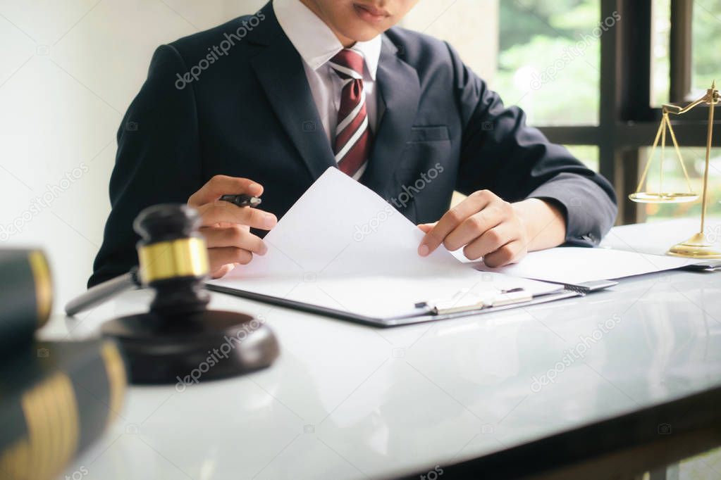 Justice and lawfirm concept.Male lawyer in the office with brass scale