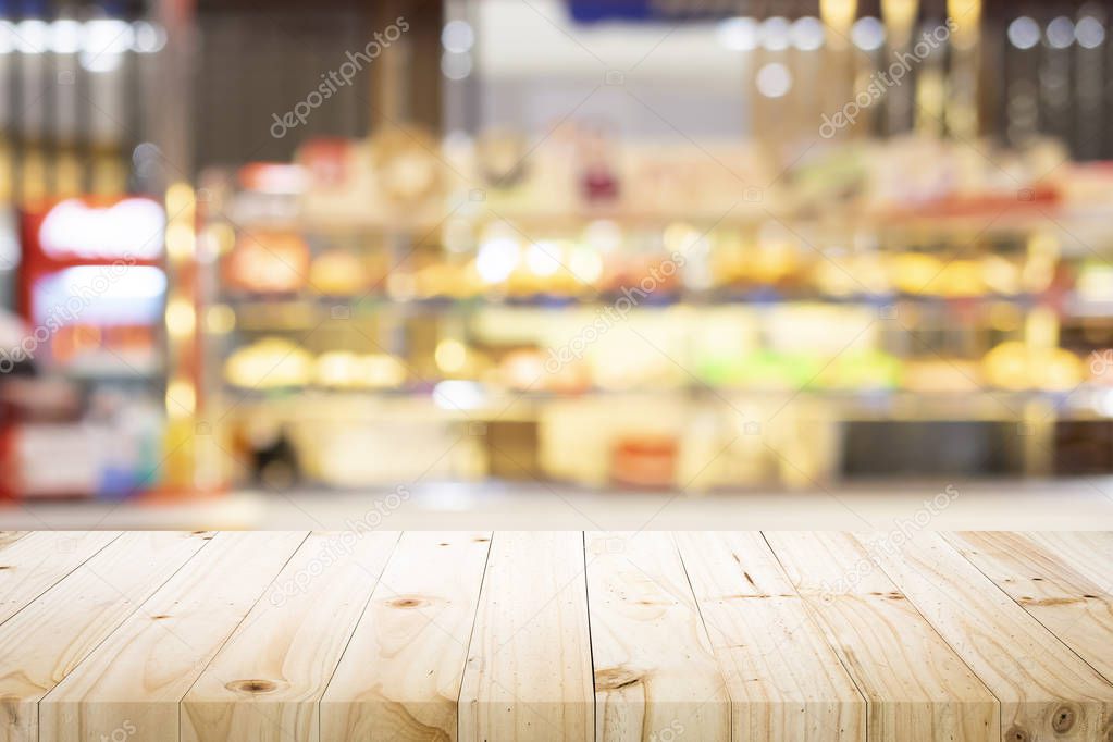 Empty wooden table for present product on coffee shop or soft drink bar blur background with bokeh image