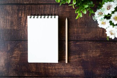 Ahşap masa üstünde boş defter. Boşaltmak ve yaratıcı metin için arka plan. 