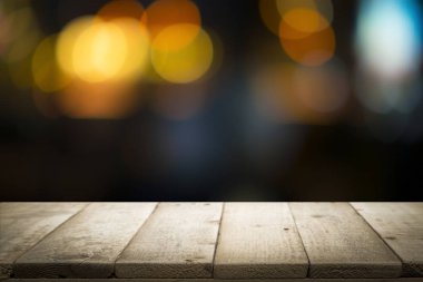 Boş ahşap masa platformu ve bokeh geceleri.