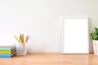 Fotoğraf çerçevesinin sahte üzerinde tablo woodden. Kitap, kalem ve boş fotoğraf çerçevesi ile çalışma tablosunun sapce kopyalamak.