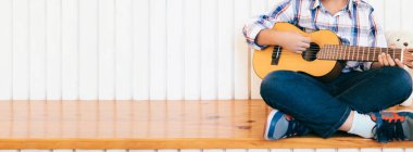 Çocuk Çocuk evde gitar çalmak. Müzik eğitimi ve ders dışı ders. 