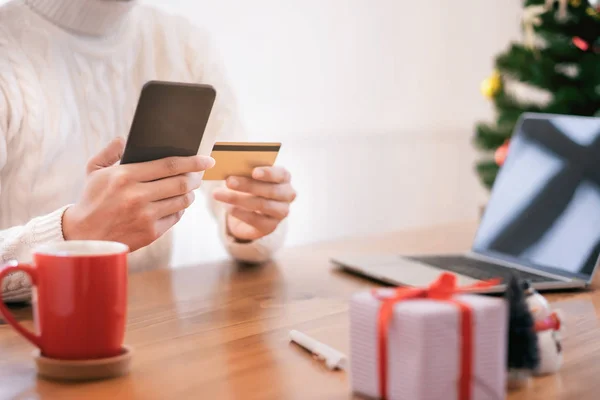 Man holding credit card and doing shopping online. New year, Christmas gift shopping