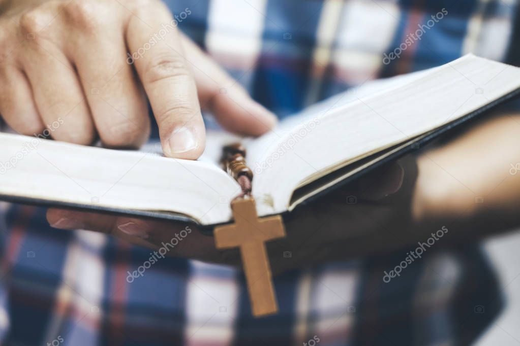 Religion Christianity concept. Man holding and reading the holy Christian Bible