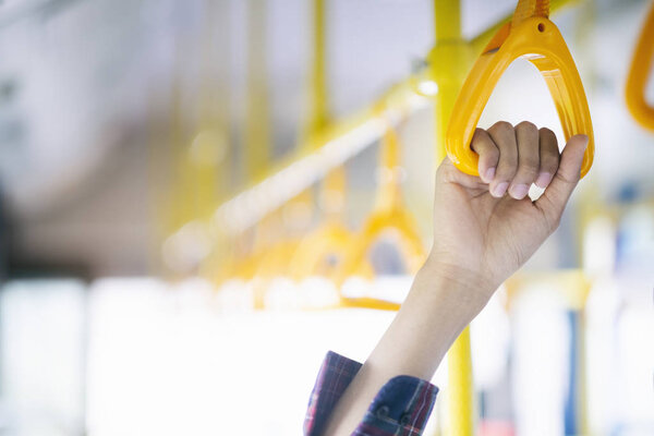 Closeup passenger  hand holding handle on the public transportation. 