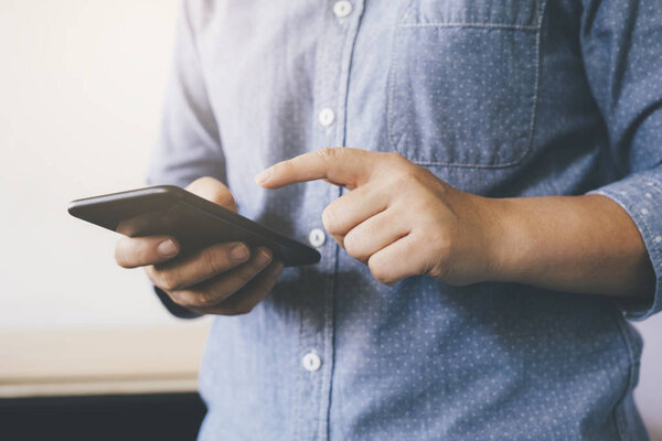 Casual man using a smart phone texting messages. 