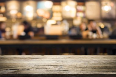 Kahve dükkanındaki mevcut ürün için boş ahşap masa ya da Bokeh imajı olan yumuşak içecek bar bulanık arkaplan