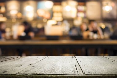 Kahve dükkanındaki mevcut ürün için boş ahşap masa ya da Bokeh imajı olan yumuşak içecek bar bulanık arkaplan