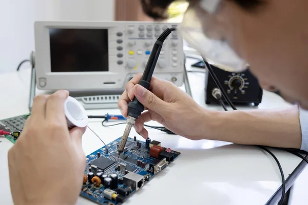 Teknikern kontrollerar den elektroniska enheten. — Stockfoto