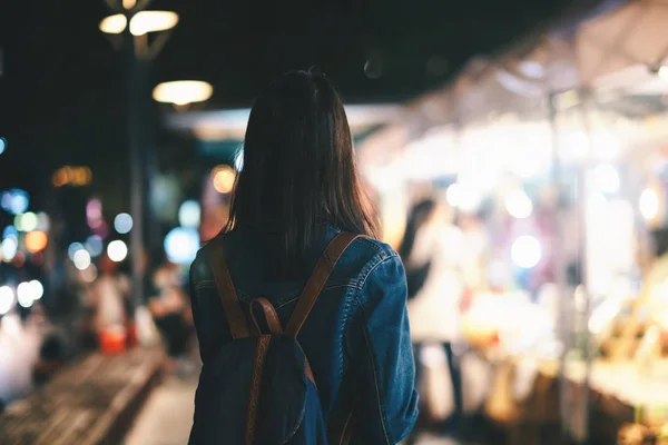 Mujer viajera joven caminando por la calle de la ciudad por la noche . — Foto de Stock
