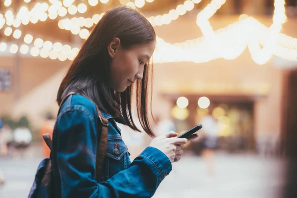 Teen girl using mobile phone to chat and send message.