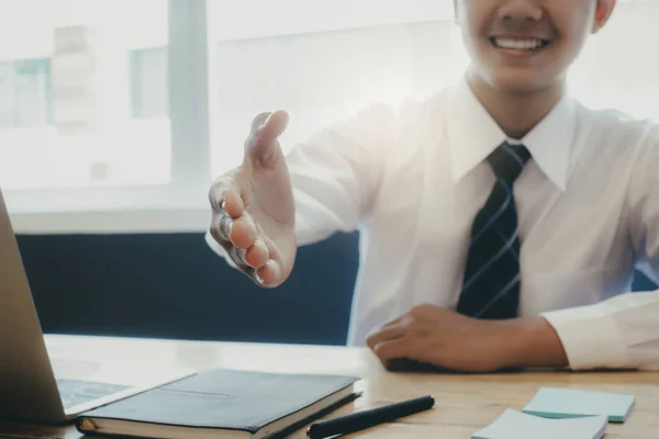 Jovem empresário asiático estendendo seu braço em um aperto de mão . — Fotografia de Stock