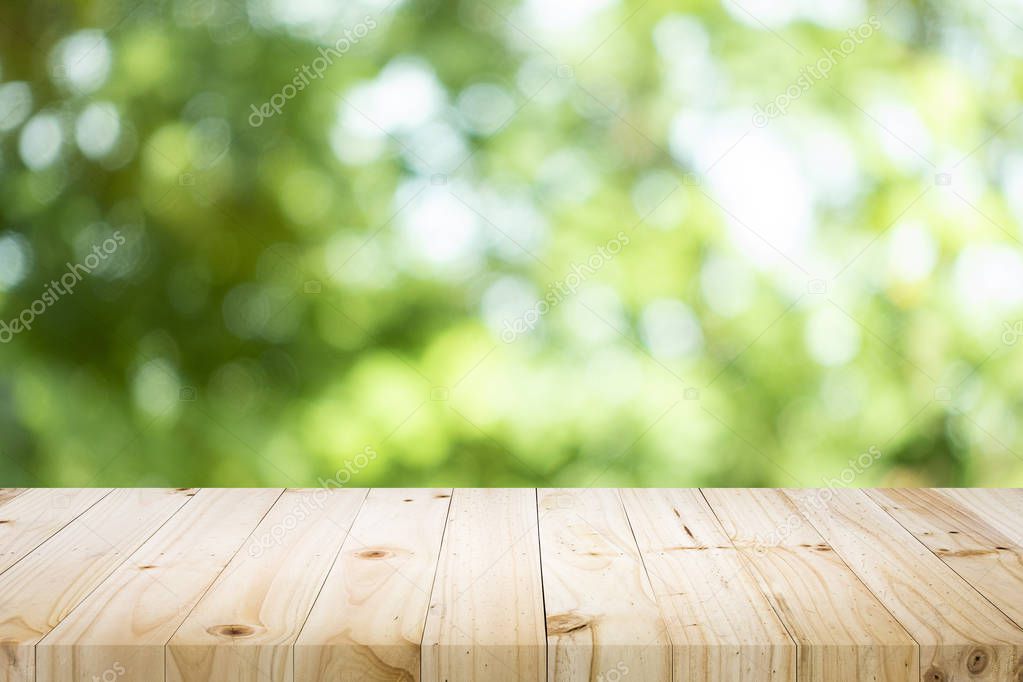Empty table for present product with green bokeh out of focus ba