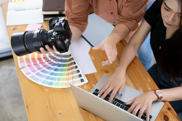 Photo artist and graphic desginer selecting pictures from camera — Stock Photo, Image