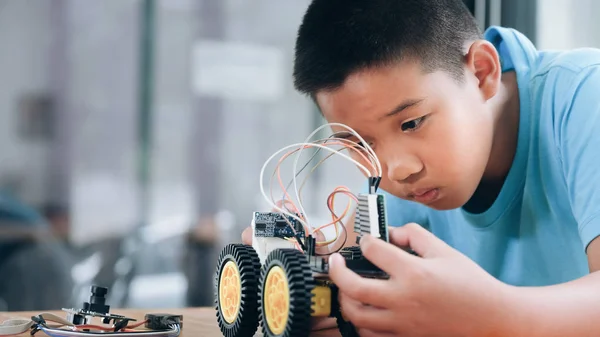 Laboratuvarda robot yaratan konsantre çocuk. — Stok fotoğraf