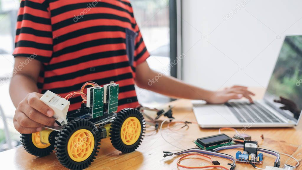 Boy with tablet pc computer programming electric toys and buildi