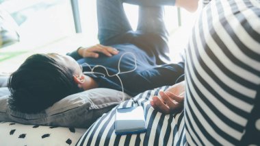 Genç adam dinleniyor. Cep telefonundan müzik dinliyor.. 