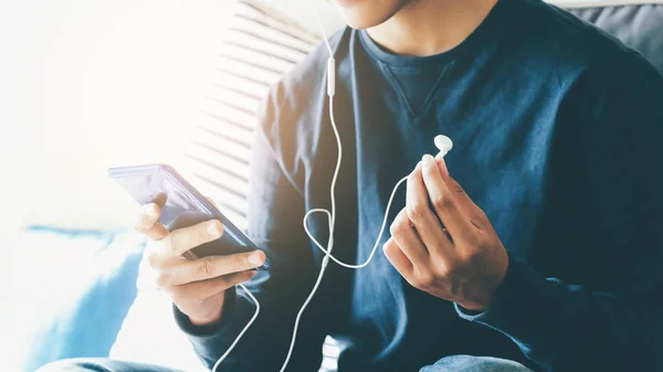 Jongeman ontspannen luisteren naar de muziek van mobiele telefoon. — Stockfoto